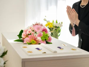 棺と合掌する喪服を着た女性