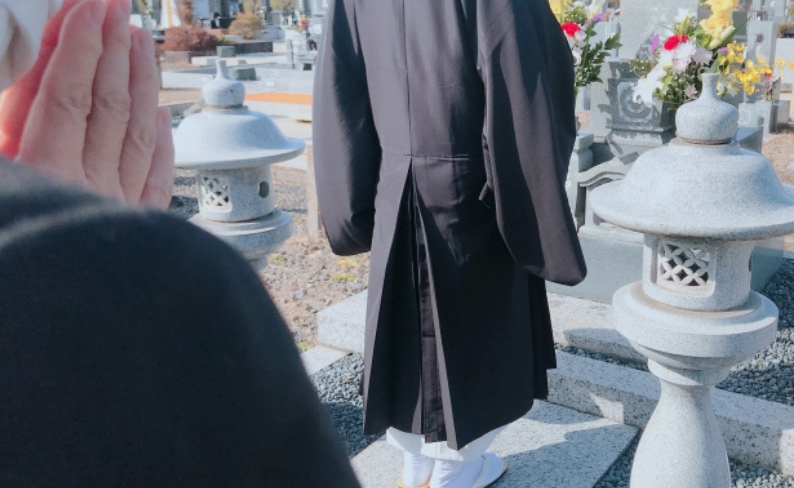墓前で読経するお坊さん